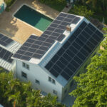 Casa com painéis solares no telhado vista de cima, ao lado de uma piscina.